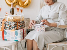 Elderly woman unwrapping birthday gifts